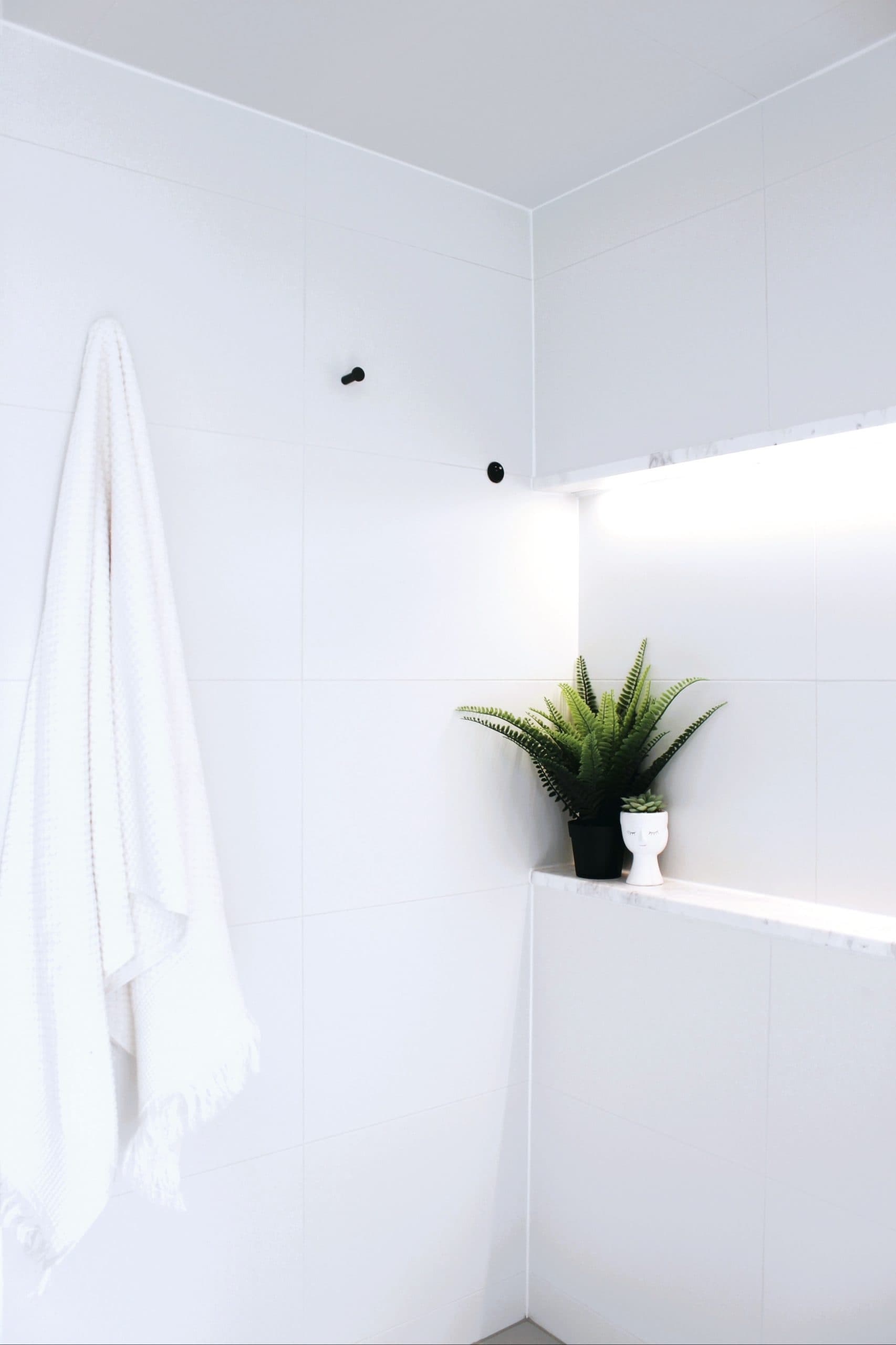 Crisp tiles and shelving detail in a Canberra bathroom