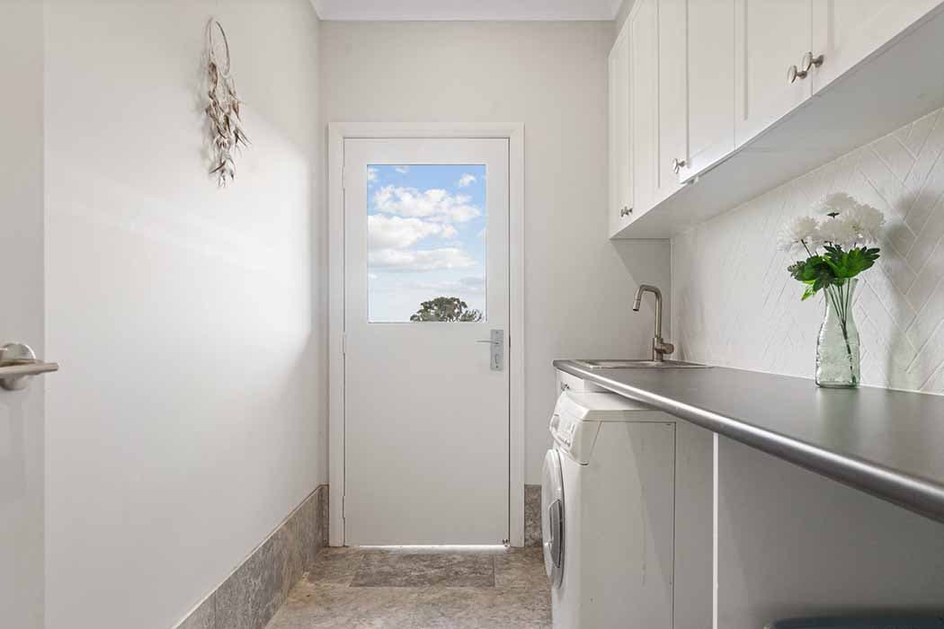 Modern laundry renovation in Canberra, Australia with stylish finishes and ample storage.