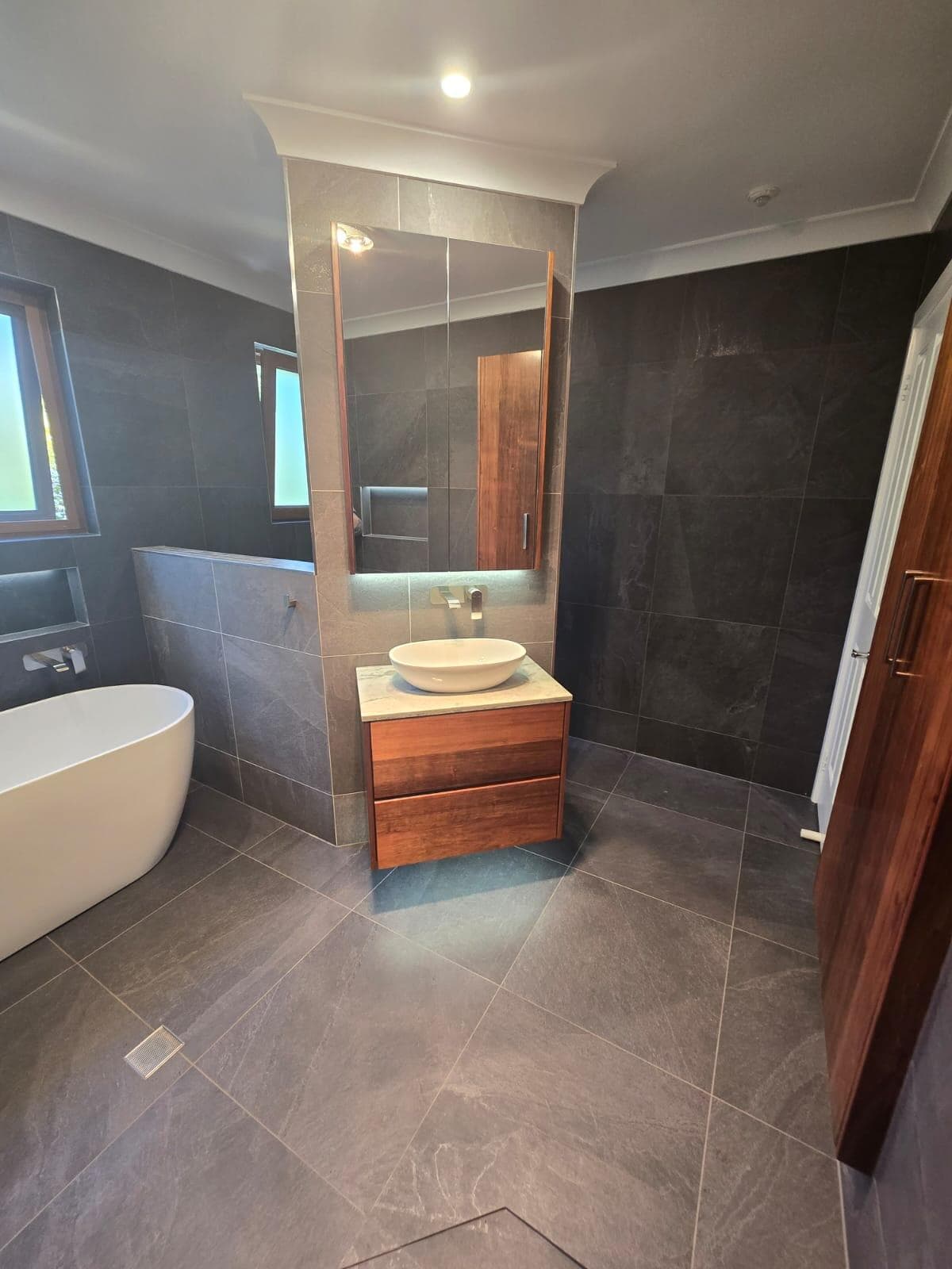 Modern bathroom renovation in Canberra, featuring slate tiles and elegant fixtures.