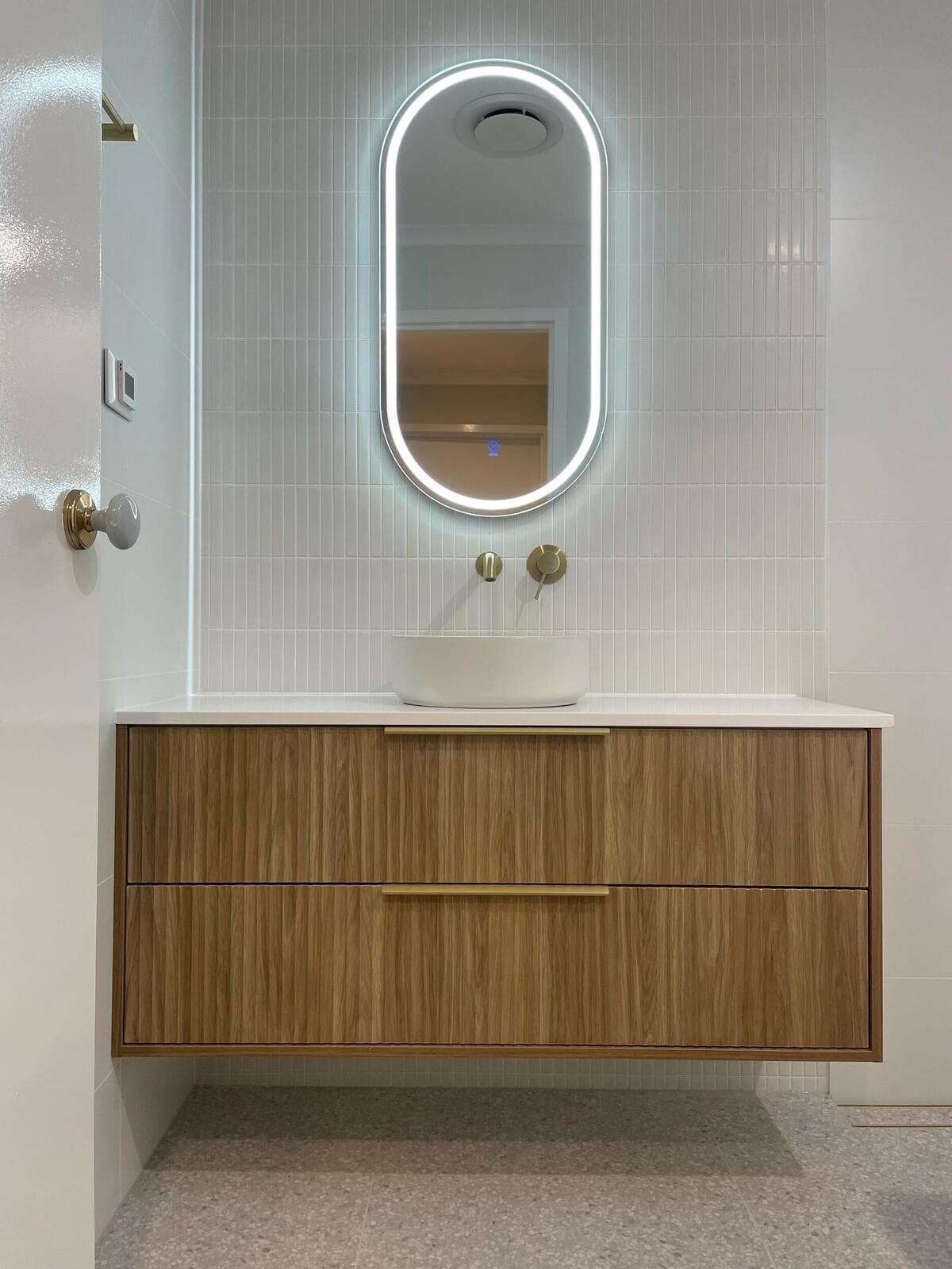 Modern bathroom renovation in Canberra with wooden vanity and LED mirror