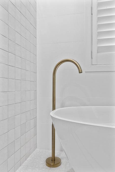 Modern bathroom renovation in Canberra with freestanding tub and brass fixtures