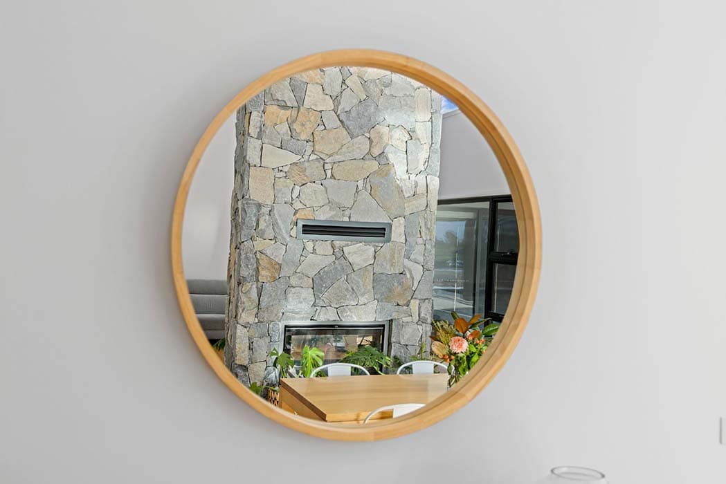 Modern interior with stone feature wall and round mirror in Canberra, Australia