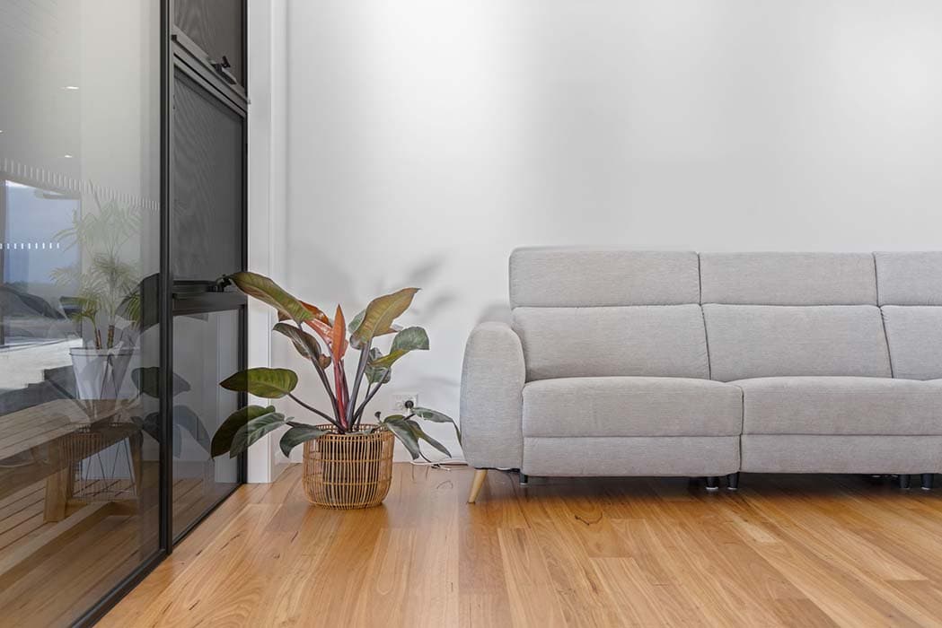 Modern living room with grey sofa and timber flooring in Canberra, Australia