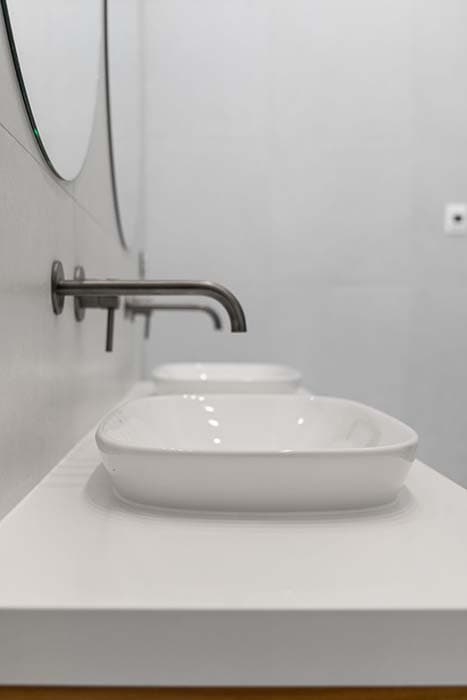 Modern bathroom renovation in Canberra with sleek sinks and wall-mounted faucets
