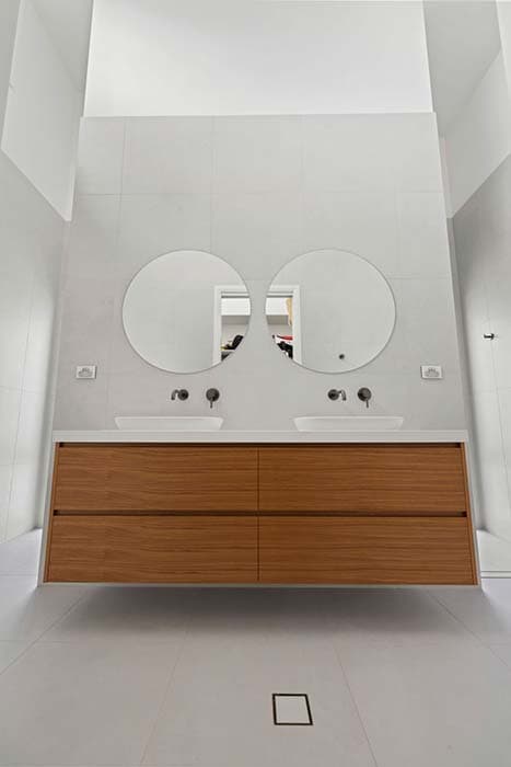Modern bathroom renovation in Canberra with timber vanity and circular mirrors