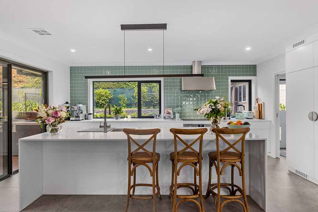 Modern kitchen renovation in Canberra, Australia with green tiles and open layout.