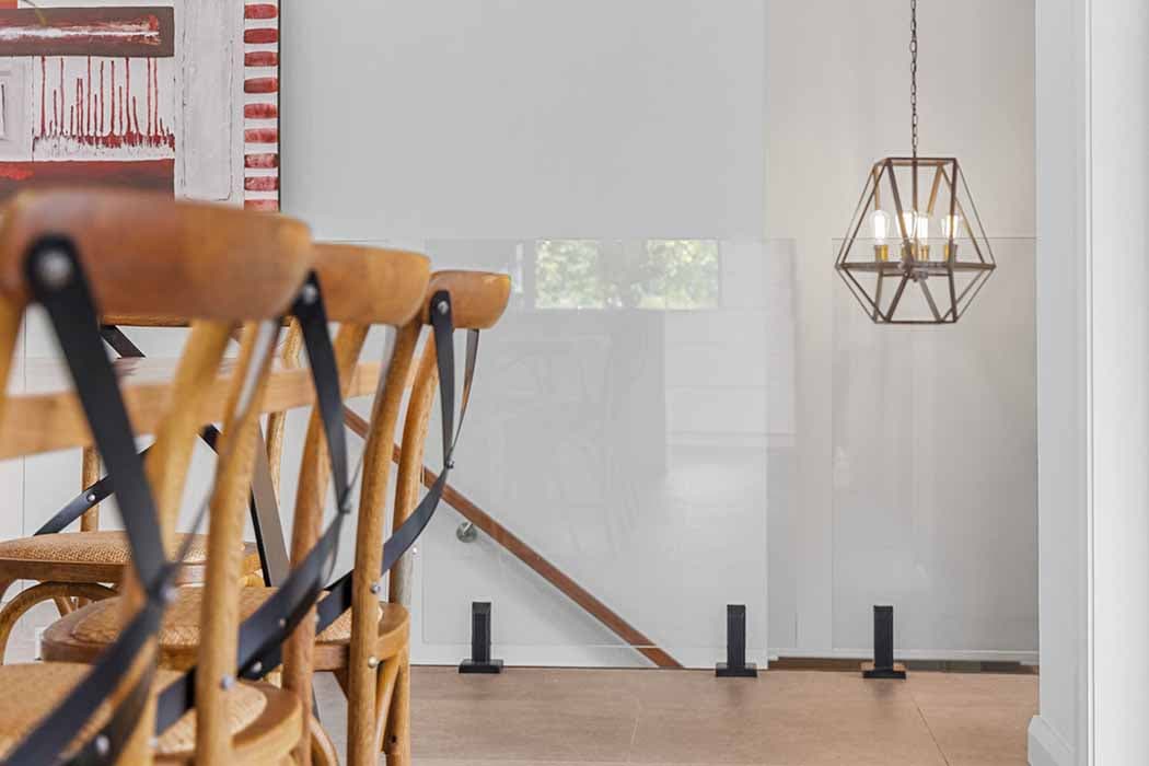 Modern dining area renovation in Canberra, featuring wooden chairs and stylish lighting.