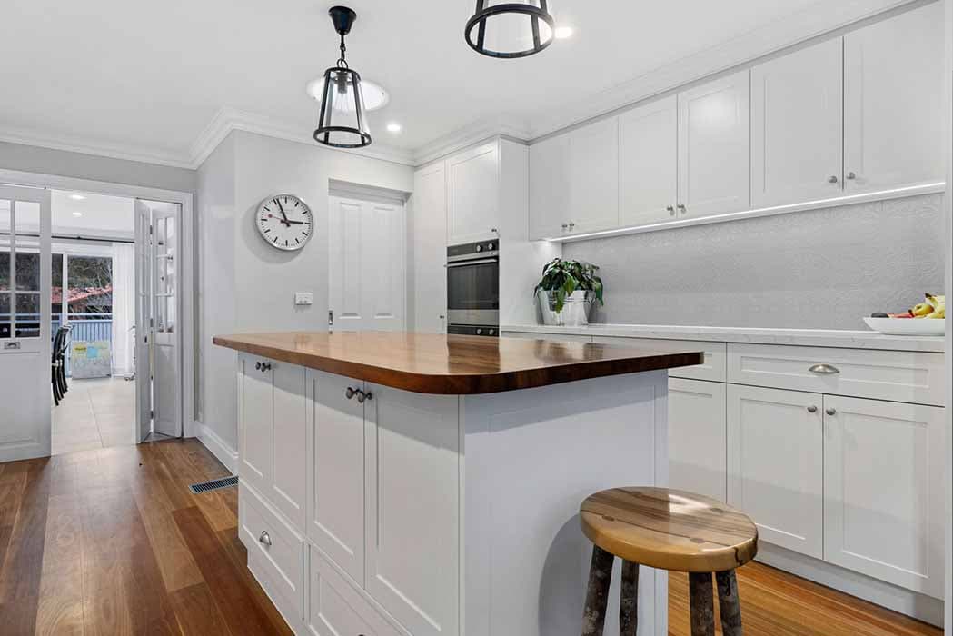 Modern kitchen renovation in Canberra, Australia with timber island and white cabinetry.