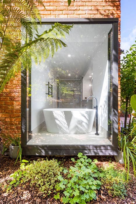 Modern bathroom renovation in Canberra with freestanding tub and glass enclosure.