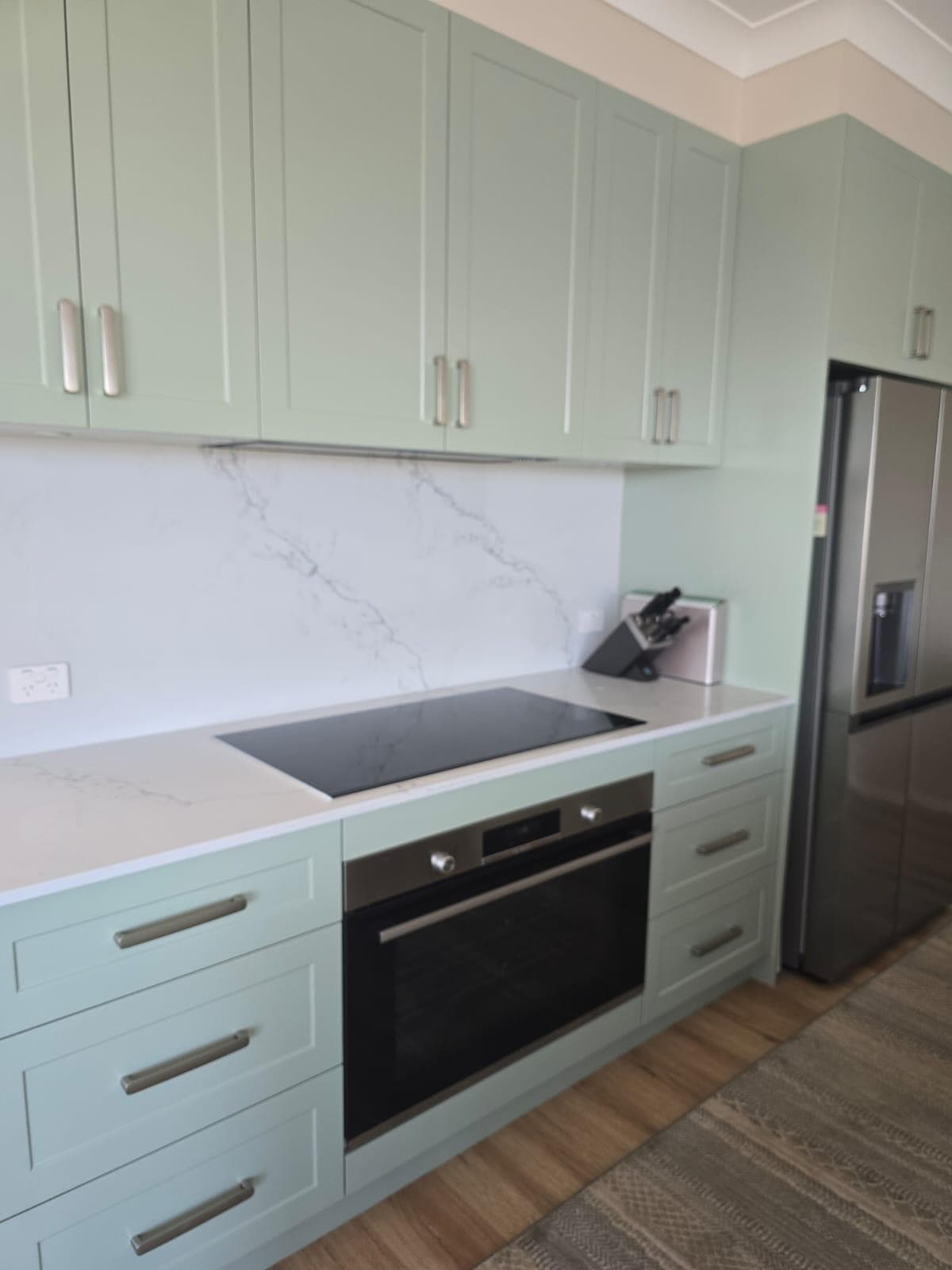 Modern kitchen renovation in Canberra with green cabinetry and elegant finishes.