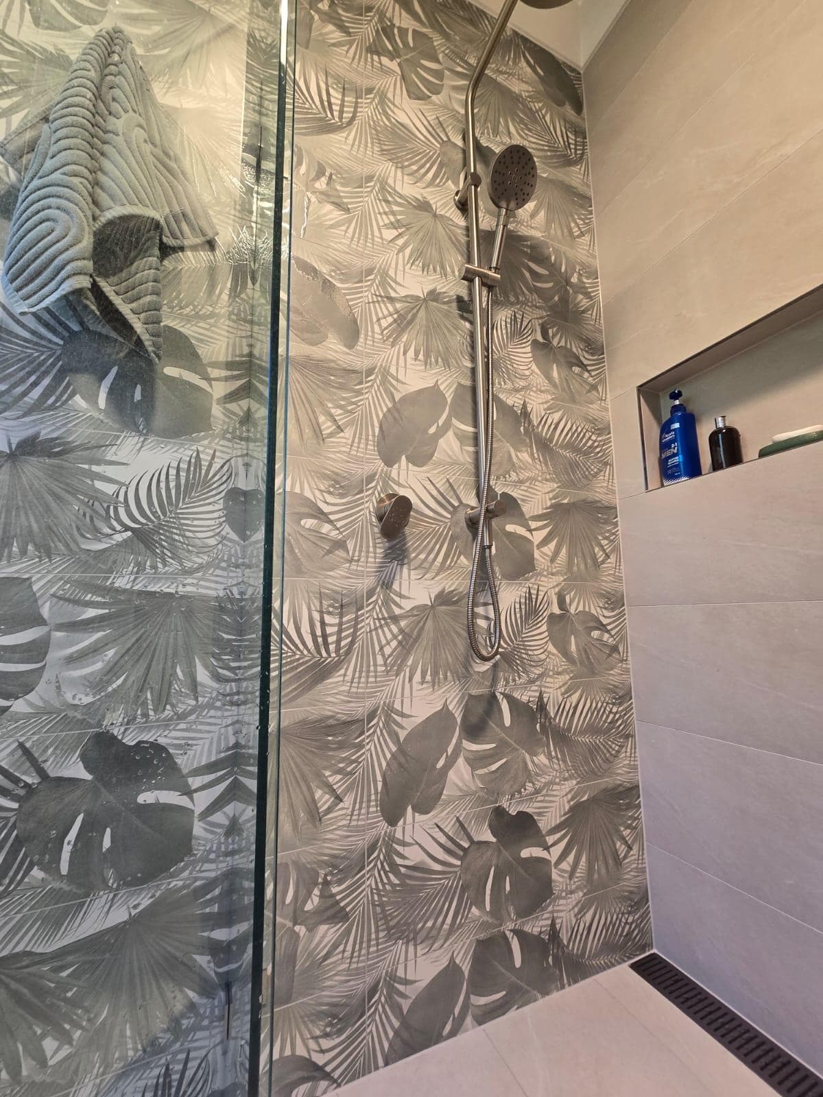 Modern shower renovation in Canberra with tropical leaf tiles and sleek fixtures