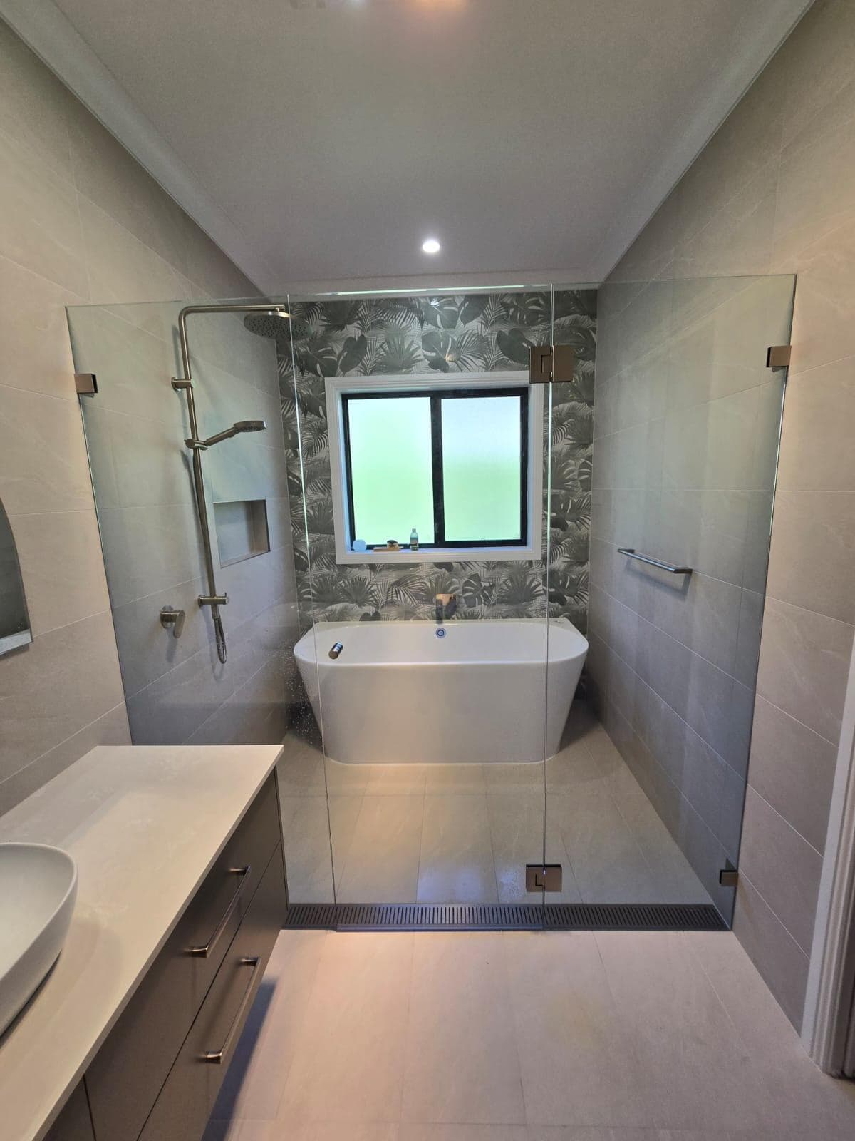 Modern bathroom renovation in Canberra, featuring freestanding tub and walk-in shower.