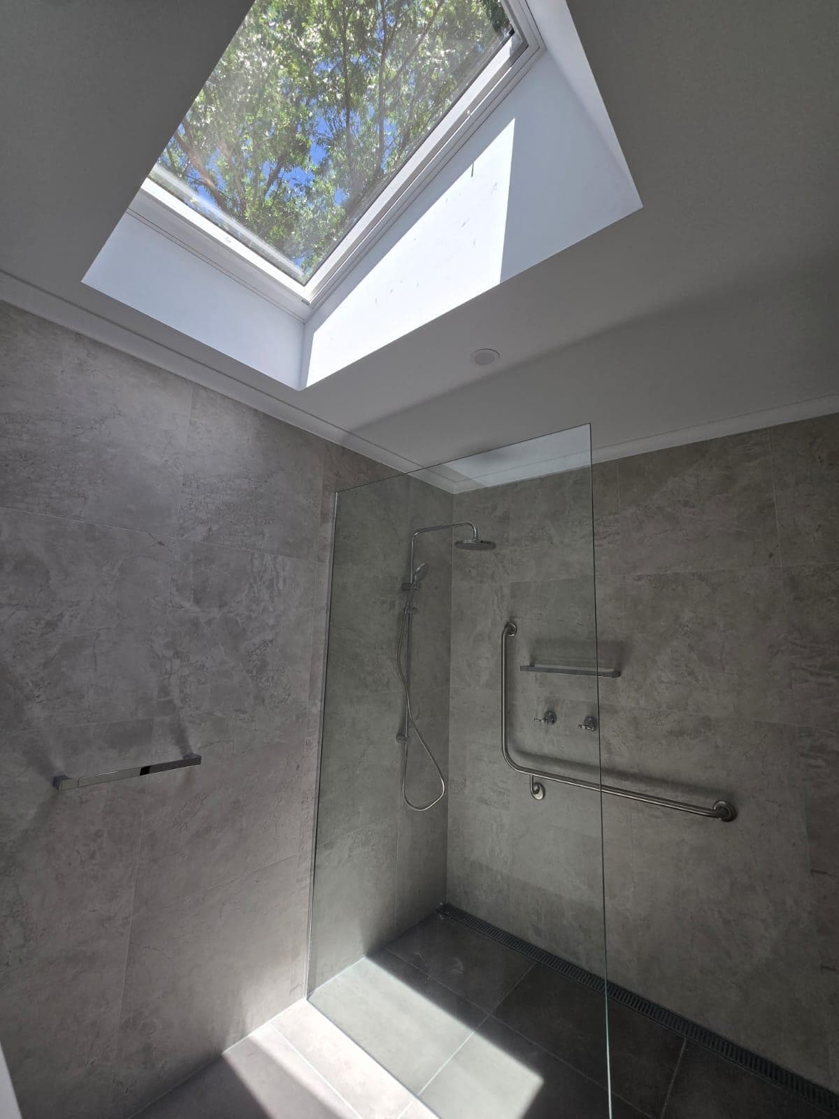 Modern bathroom renovation in Canberra with skylight and walk-in shower
