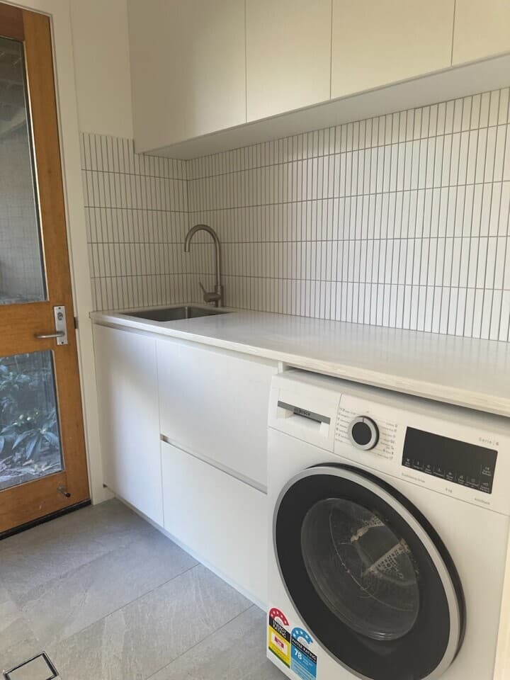 Modern laundry renovation in Canberra, Australia with sleek cabinetry and stylish fixtures.