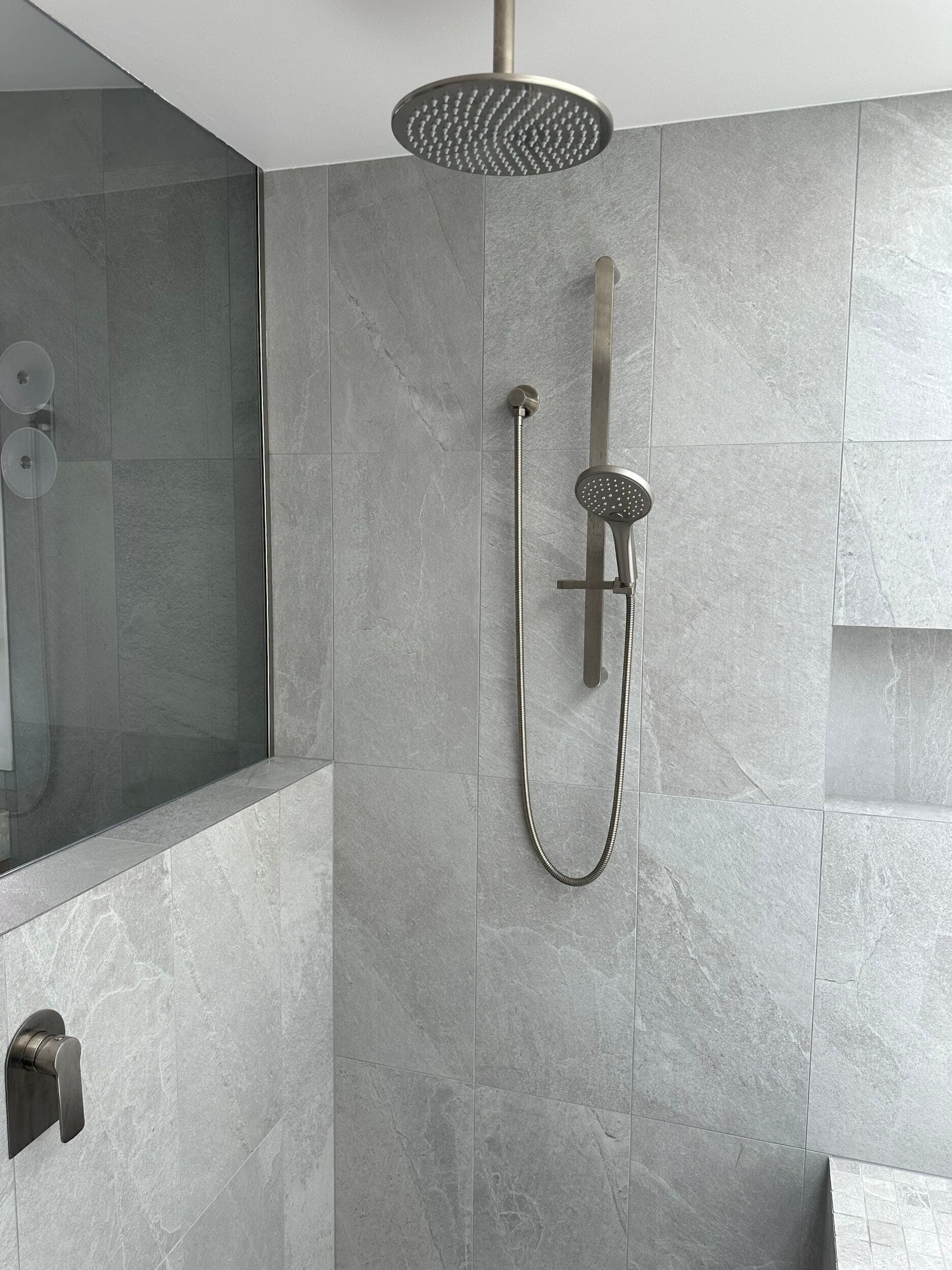 Modern bathroom renovation in Canberra with sleek gray tiles and stylish fixtures.