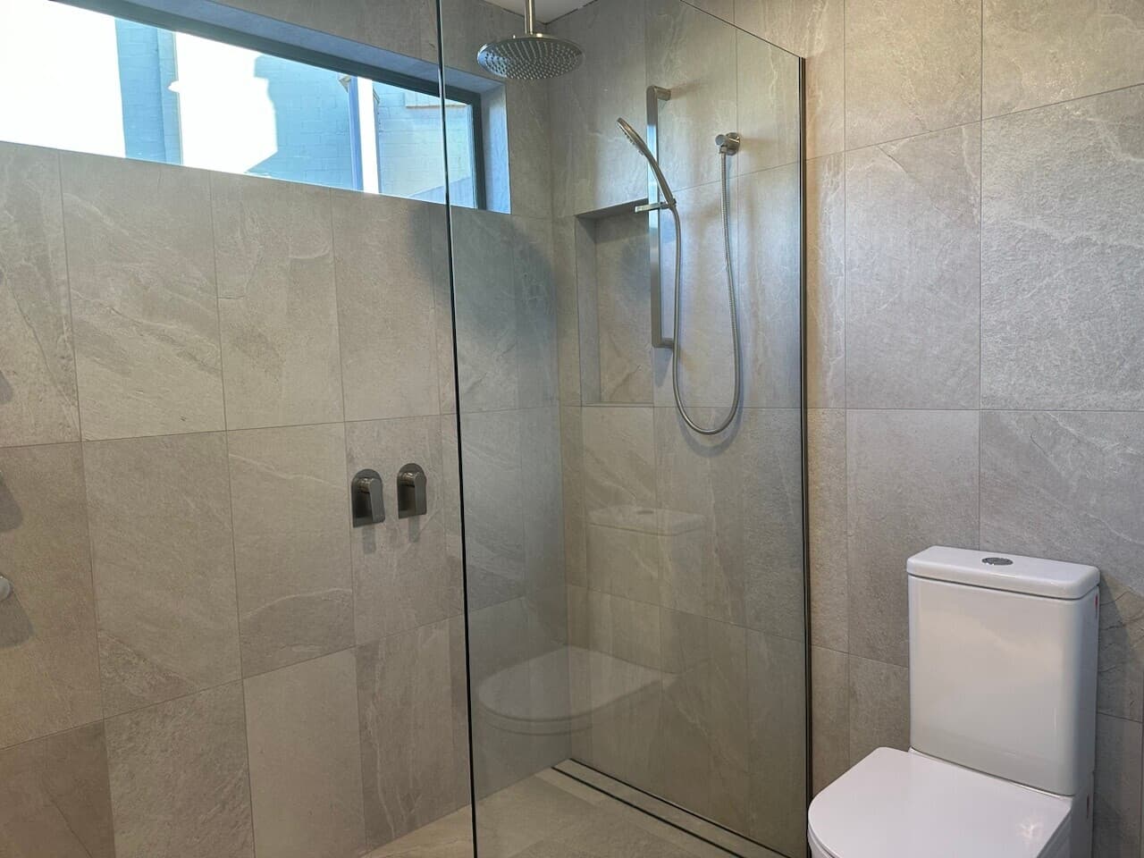 Modern bathroom renovation in Canberra with sleek tiles and walk-in shower