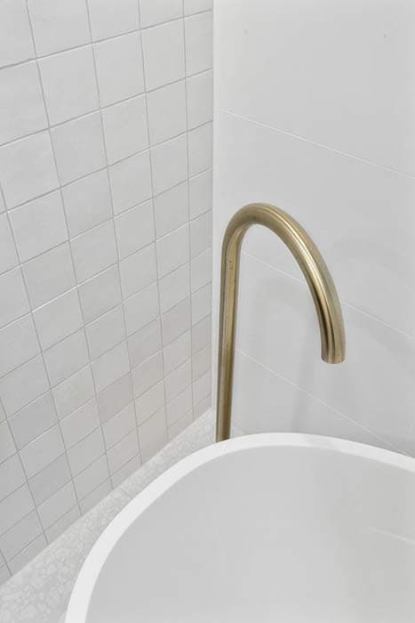 Modern bathroom renovation in Canberra with elegant tub and gold faucet